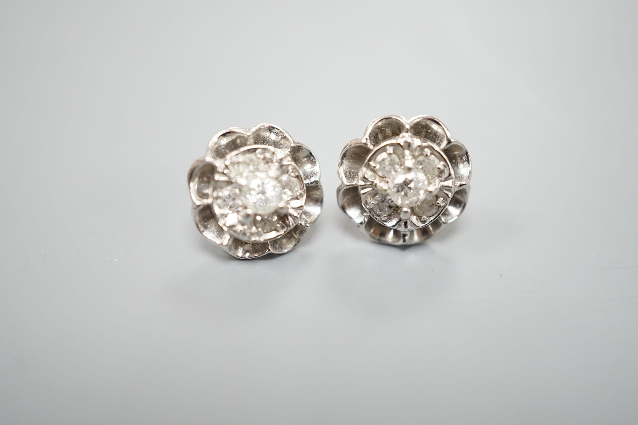 A pair of 750 white metal and five stone diamond cluster set earrings, 10mm, gross weight 3.2 grams.